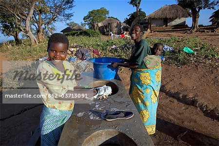 Malawi, Lilongwe, Ntchisi Forest Reserve. In a small mountain village woman gather at the communal washing area. Malawi, Lilongwe, Ntchisi Forest Reserve. In a small mountain village woman gather at the communal washing area.