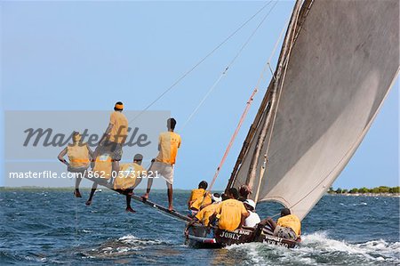 Kenya. A Mashua sailing boat with an outrigger participating in a race off Lamu Island.