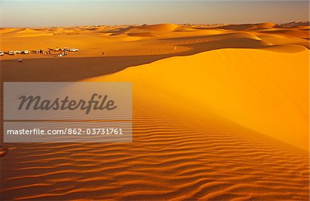 Libya, Fezzan, Erg Uan Kasa. Tourists set up a wild campsite in the midst of the Erg Uan Kasa dunes between the Jebel Akakus and the Messak Settafet.