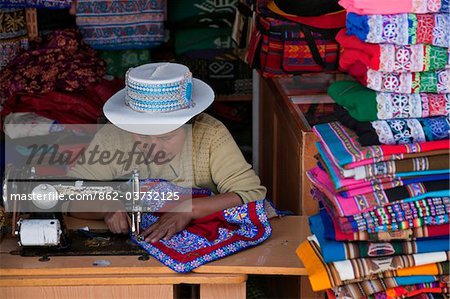 Peru, A woman uses her sewing machine to embroider cloth in a shop at Chivay, the provincial capital of Caylloma.
