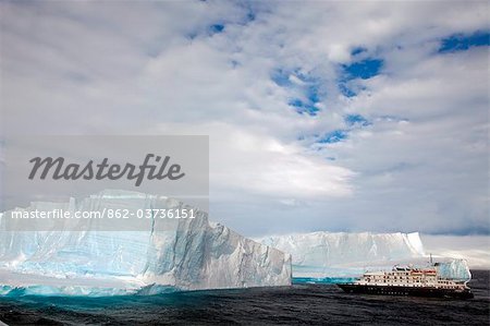 Antarctica, Antarctic Sound and Hope Bay, expedition ship the Corinthian III is dwarfed by the tabular icebergs.