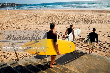 Australia, New South Wales, Sydney.  Surfers head for the water at Manly Beach.