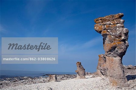 Sweden, Island of Gotland, Fårö.  Limestone rock formations called Rauks creating by marine erosion. Highlighted is one of the larger formations known as Langhammar or 'Long Hammer'