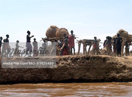 A Dassanech woman takes grain from her familys grain store situated on a bank of the Omo River in Southwest Ethiopia.The villagers food reserves are kept high off the ground in semi circular granaries in case of flooding.