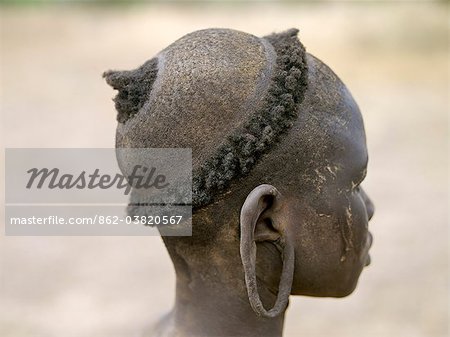 The typical hairstyle of a young Mursi girl.The Mursi speak a Nilotic language and have affinities with the Shilluk and Anuak of eastern Sudan.They live in a remote area of southwest Ethiopia along the Omo River, the countrys largest river.