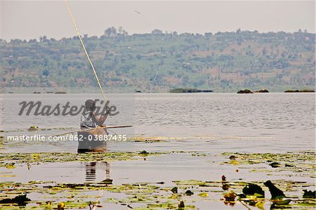 Burundi. A man fishes from a dugout canoe on the Lac des Oiseaux.