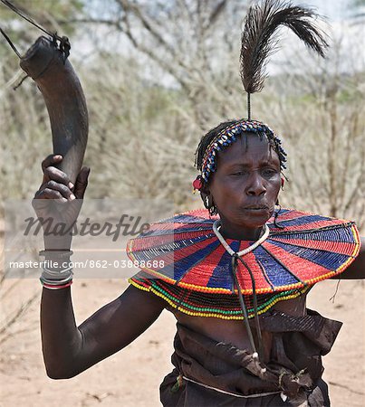 An old Pokot woman dancing during an Atelo ceremony. The cow horn container usually contains animal fat. Kenya