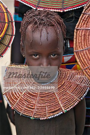 A young Pokot girl wearing a traditional broad necklace made of hollow reed grass that denotes her uninitiated status. The Pokot are pastoralists speaking a Southern Nilotic language.