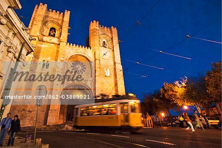 Tramway in the Alfama district at dusk, passing by the Se Catedral (Motherchurch). Lisbon, Portugal