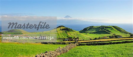 Volcanic craters along the Sao Jorge island and the Pico volcano on the horizon. Azores islands, Portugal