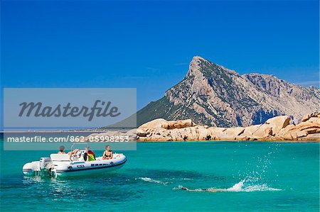 Italy, Sardinia, Olbia-Tempo, Monte Petrosu. Tourists enjoying the scenery by boat.