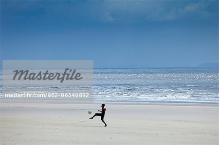 South America, Brazil, Maranhao, Sao Luis, Sao Marcos beach, boy playing football on the beach