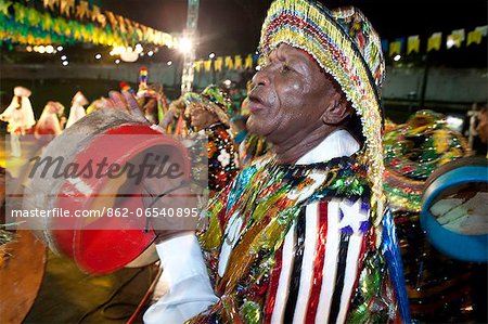 South America, Brazil, Maranhao, Sao Luis, a costumed dancer with tamborim drum instrument at the Bumba Meu Boi festival in the Praca Aragao