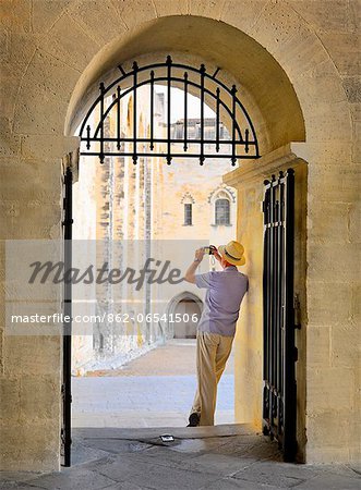 France, Provence, Avignon, Palais de Papes, Man photographing through archway MR France, Provence, Avignon, Palais de Papes, Man photographing through archway MR