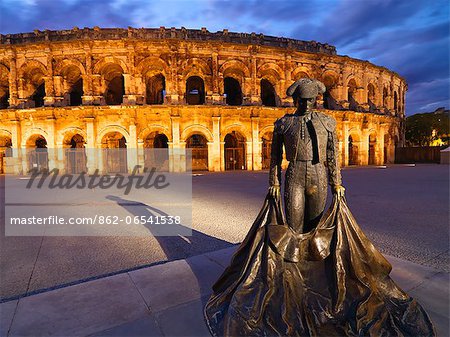France, Provence, Nimes,  Roman ampitheatre, Toreador statue at dusk