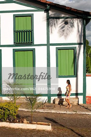 South America, Brazil, Goias, Pirenopolis, a woman walks past Portuguese colonial houses on the Rua Nossa Senhora do Rosario in the mining town of Pirenopolis near Brasilia