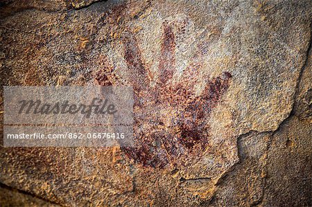 Chad, Elikeo, Ennedi, Sahara. A handprint on a cave wall superimposing earlier white artwork. Probably early Pastoral Period. Chad, Elikeo, Ennedi, Sahara. A handprint on a cave wall superimposing earlier white artwork. Probably early Pastoral Period.
