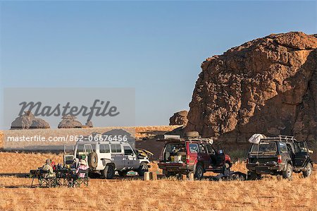 Chad, Abaike, Ennedi, Sahara. Visitors to Abaike having breakfast after packing up camp.