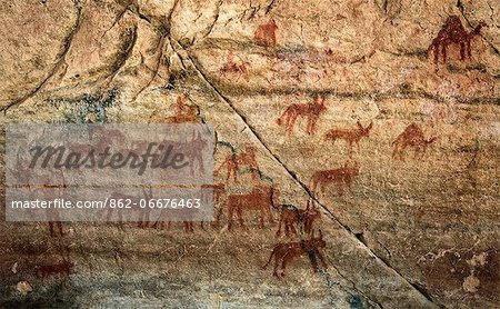 Chad, Bakabi, Ennedi, Sahara. A rock art panel of a figure, perhaps holding saplings, with animals which include Barbary sheep.