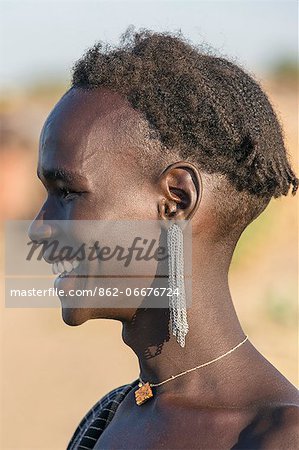 A young Dassanech man with a bunch of small chain in his pierced earlobes, Ethiopia