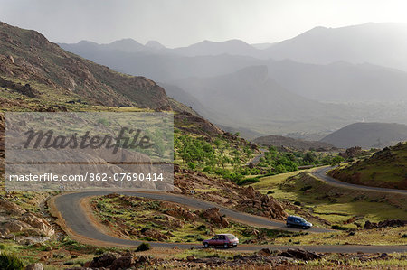 Morocco, Anti-Atlas Mountains, Tafraoute. Cars navigate a winding mountain road near Tafraoute.