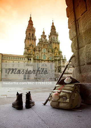 Spain, Galicia, A pilgrim s rucksack, boots, walking stick and hat with shells, the symbols of the Camino di Santiago at the arrival on the main square with the historical cathedral in the background