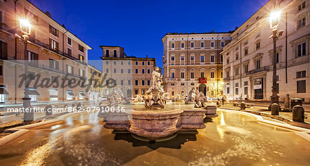 The Fontana del Moro at the southern end of the Piazza Navona with a basin and four Tritons sculpted by Giacomo della Porta and additions by Bernini, at twilight, Piazza Navona, Parione, Rome, Lazio, Italy.