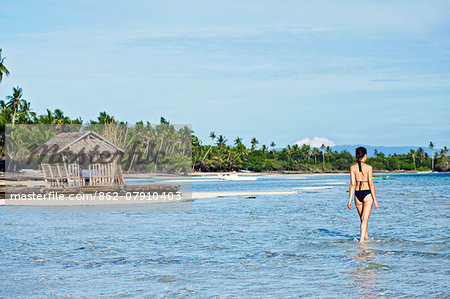 Asia, South East Asia, Philippines, Visayas, Bohol,  a model walking through shallow sea on Doljol beach, Panglao island MR