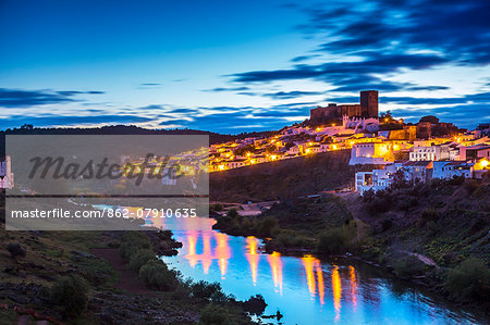 Sunset view over Guadiana River to old town with castle, Mertola, Alentejo, Portugal