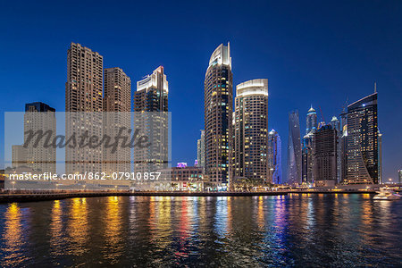 Dubai Marina at twilight with the Cayan Tower (Infinity Tower), the Dubai Marriott Harbour Hotel and Suites and various residential towers, Dubai Marina, Dubai, The United Arab Emirates.