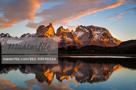 Chile, Torres del Paine, Magallanes Province. Sunrise over Torres del Paine reflected in the waters of Lake Pehoe in the foreground. One of the principal attractions of the National Park is the magnificent Paine massif.