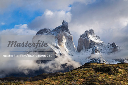 Chile, Torres del Paine, Magallanes Province. The impressive peaks of Cuernos del Paine wreathed in cloud. The highest peak is known as Cuerno Principal.