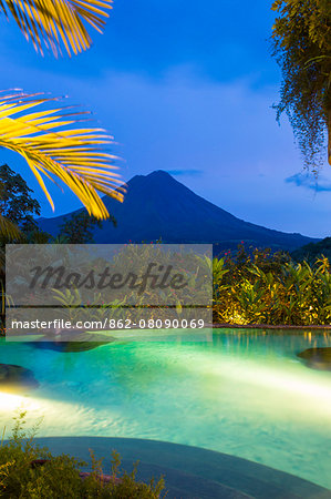 Costa Rica, Alajuela, La Fortuna. The Arenal volcano and swimming pool at The Springs Resort and Spa.