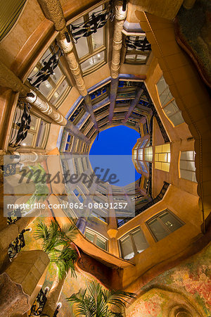 Bottom view of the inner courtyard of Casa Mila or La Pedrera at dusk, Barcelona, Catalonia, Spain