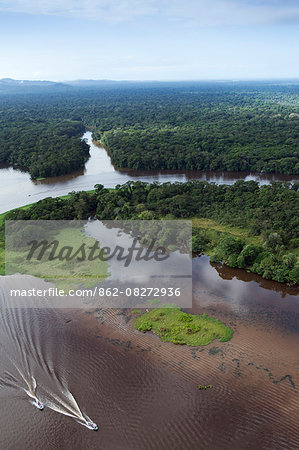 Costa Rica, Limon province, Tortuguero National Park, aerial view of a boat on the Tortuguero river and surrounding forest