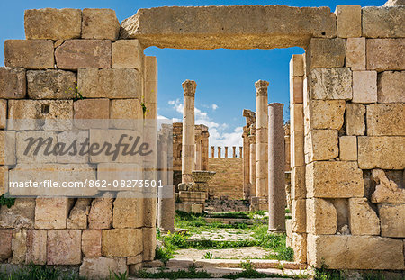 Jordan, Jerash.  The 6th century ruins of the Byzantine Church of the Propylaea viewed through the  Cardo  to the Propylaeum   the gateway leading to the Temple of Artemis in the ancient Roman city of Jerash.