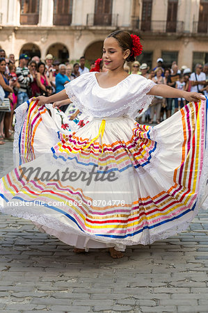 Cuba, Havana, Plaza de Armas, Habana Vieja.  A young girl participates in a public dancing display at Plaza de Armas, Havanas oldest square which was laid out in the 1520s.