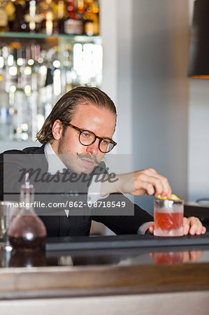 Denmark, Hillerod, Copenhagen. A barman prepares a cocktail at Hotel D'Angleterre. .