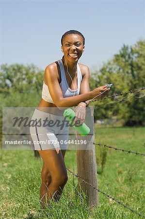 Female Jogger Resting by Fence