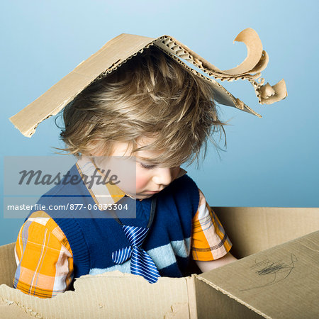 Little boy playing with cardboard