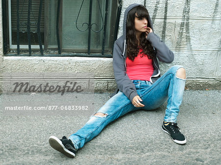 Teenage girl sitting in the street