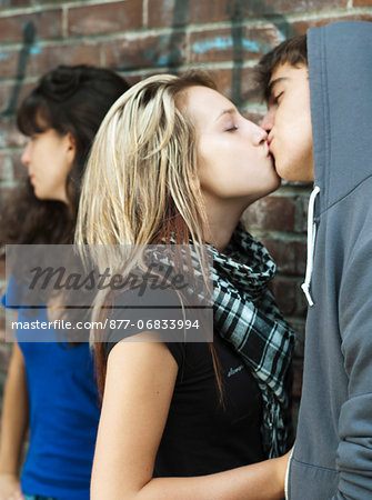 Teenagers kissing near teenage girl