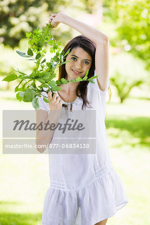 Young woman holding leaves