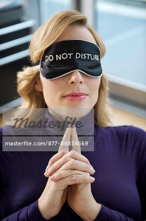 Woman with sleep mask, relaxing at office