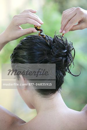 Portrait woman tying her long wet brown hair, haircare product
