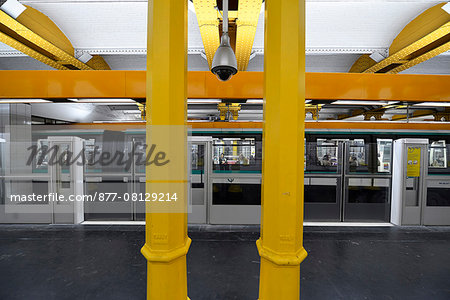 Europe, France, Paris, station Gare de Lyon Metro and yellow metal columns. A train and its passengers on the opposite platform
