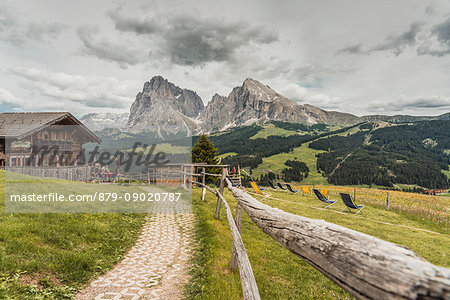 Alpe di Siusi/Seiser Alm, Dolomites, South Tyrol, Italy. View from the Alpe di Siusi to the peaks of Sassolungo/Langkofel and Sassopiatto / Plattkofel with Rauch Hutte on the left