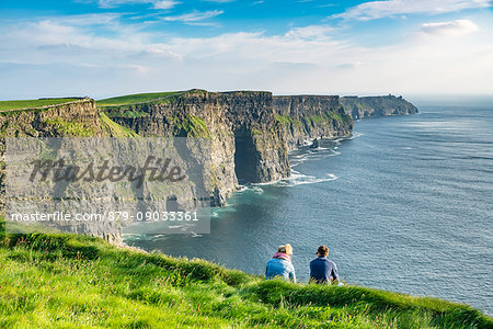 Couple admiring the landscape. Cliffs of Moher, Liscannor, Co. Clare, Munster province, Ireland.