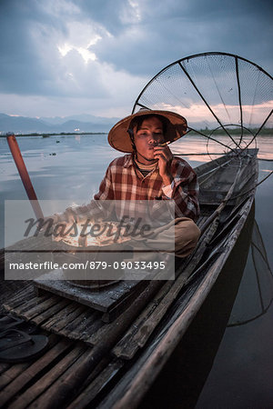 Inle lake, Nyaungshwe township, Taunggyi district, Myanmar (Burma). Local fisherman before dawn with fireplace on the boat.