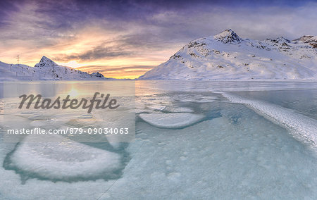 Sunrise lights the frozens surface ok White Lake at Bernina Pass. Canton of Graubuenden. Engadine. Switzerland. Europe